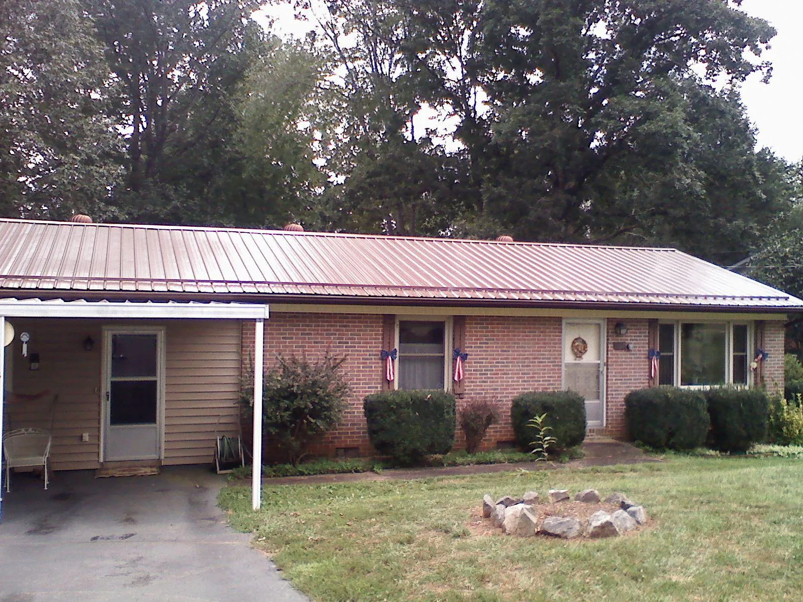 Bronze metal roof and carport on a brick ranch home — Roof Repair work by our crew in Alva
