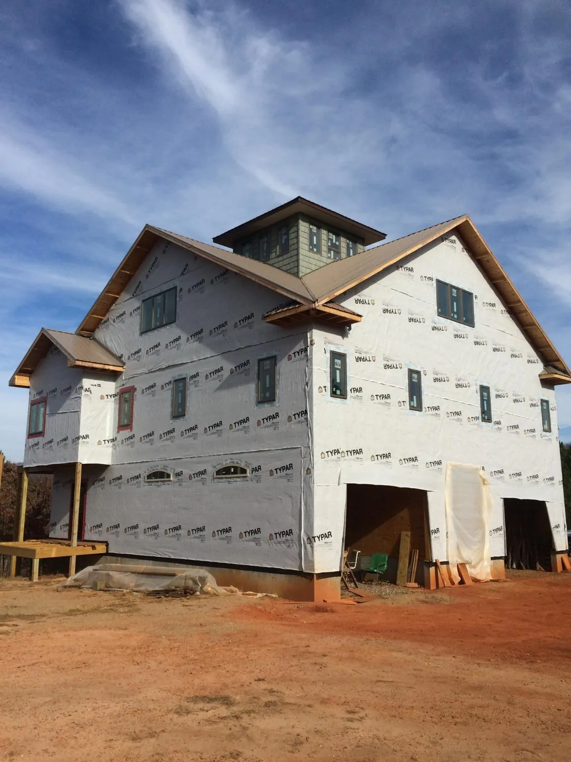 New two story house under construction with a cupola and gabled roofs in Alva